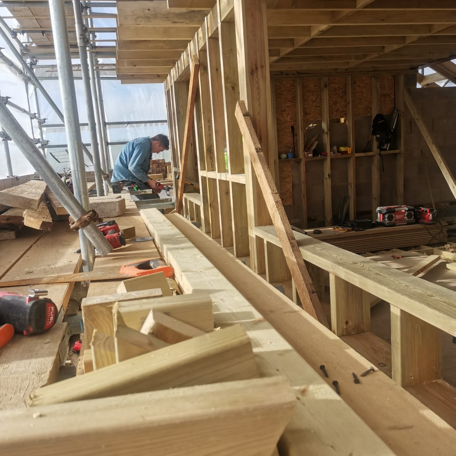 Timber stud-frame walls and roof structure under construction with scaffolding